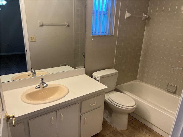 full bathroom with tile patterned flooring, vanity, tiled shower / bath, and toilet