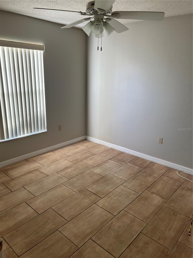 empty room featuring ceiling fan and a textured ceiling