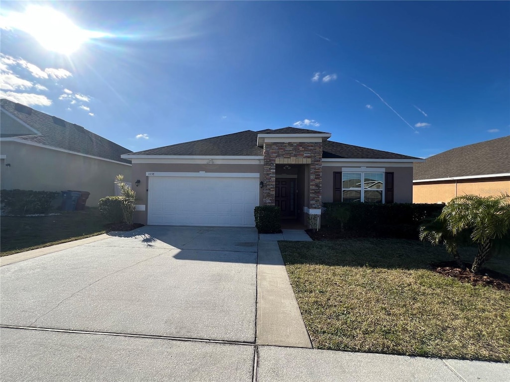 view of front of property with a garage and a front lawn