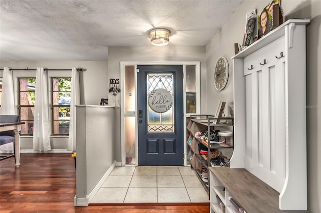 mudroom with tile patterned flooring and a textured ceiling