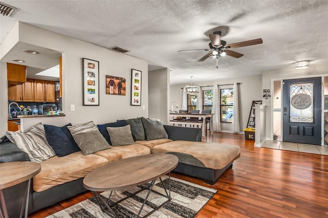 living room featuring ceiling fan, hardwood / wood-style floors, and a textured ceiling