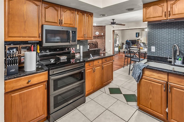 kitchen featuring ceiling fan, stainless steel appliances, sink, and decorative backsplash