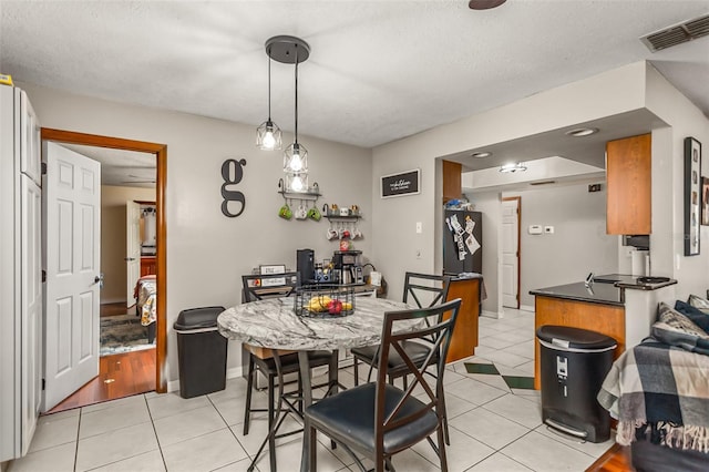 tiled dining area with a textured ceiling