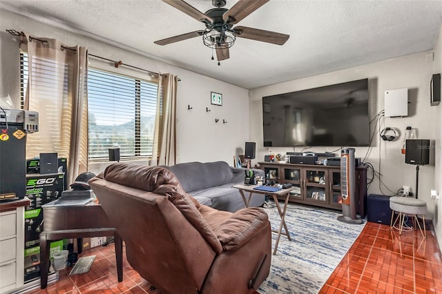 living room with ceiling fan and a textured ceiling