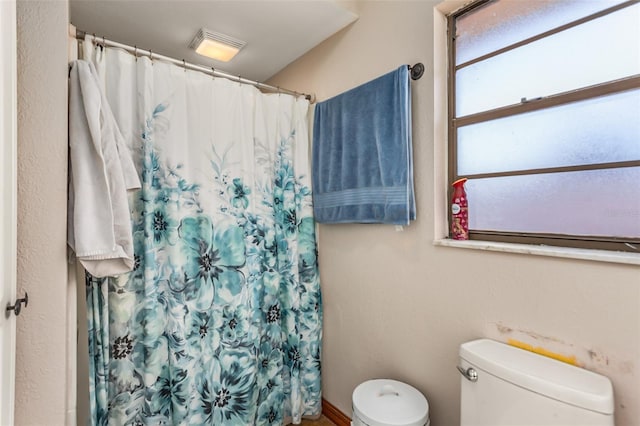 bathroom with toilet and walk in shower