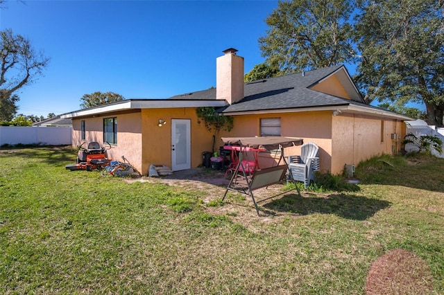 rear view of property with a lawn