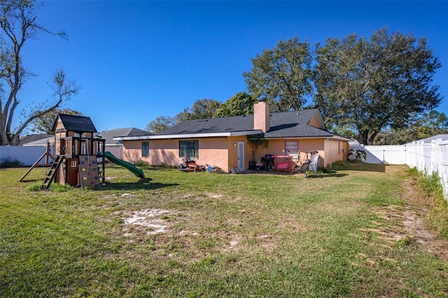 rear view of property with a playground and a lawn