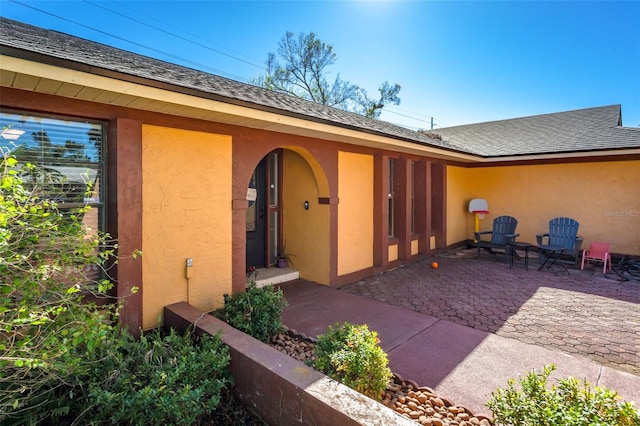 view of exterior entry with a patio area