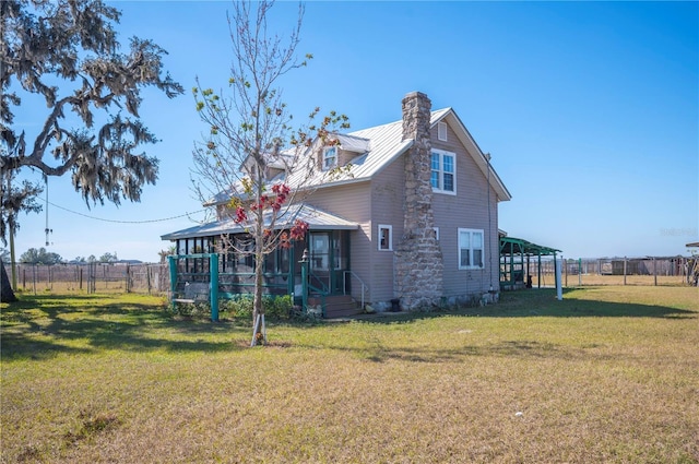 rear view of house with a sunroom and a lawn