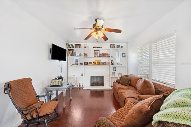 living room with ceiling fan, a fireplace, dark hardwood / wood-style flooring, and built in shelves