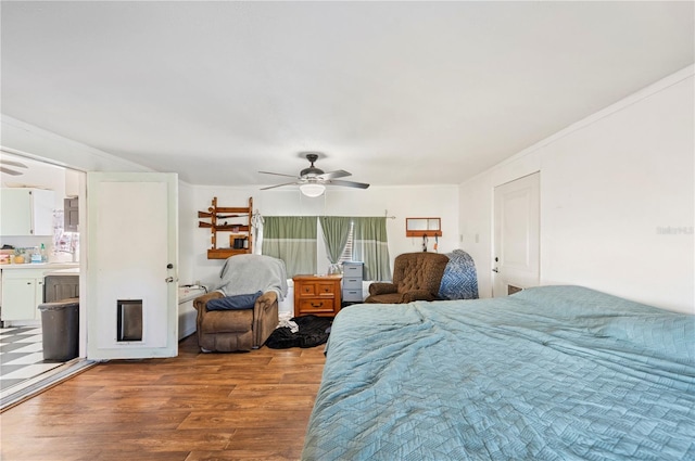 bedroom featuring hardwood / wood-style floors, crown molding, and ceiling fan