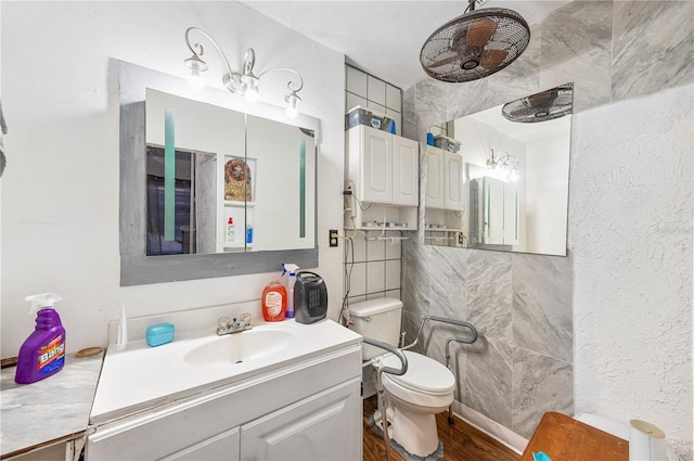 bathroom featuring vanity, wood-type flooring, tile walls, and toilet