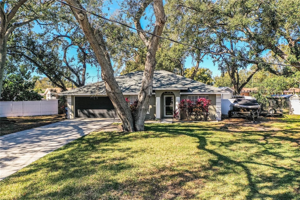 single story home with a garage and a front lawn