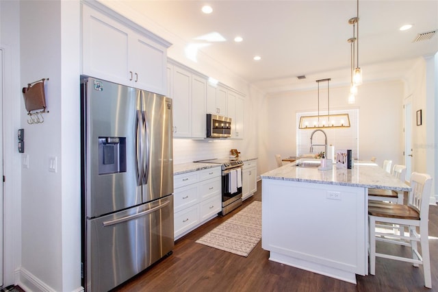 kitchen with decorative light fixtures, an island with sink, sink, white cabinets, and stainless steel appliances