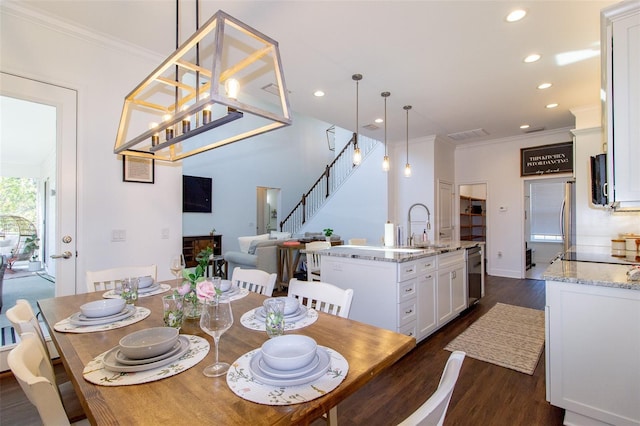 dining space featuring dark hardwood / wood-style flooring, sink, and crown molding