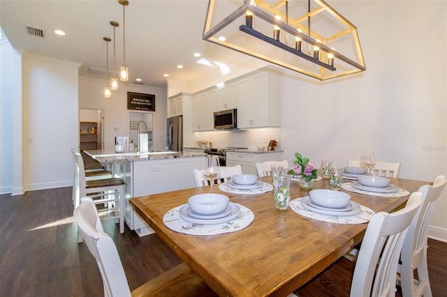 dining space with sink, ornamental molding, and dark hardwood / wood-style floors