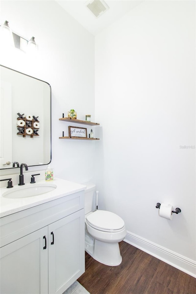 bathroom with wood-type flooring, vanity, and toilet