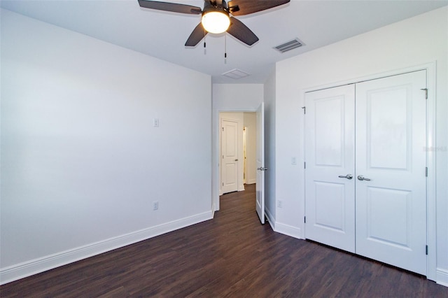 unfurnished bedroom featuring dark hardwood / wood-style floors, ceiling fan, and a closet