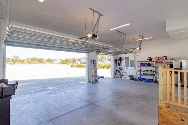 garage with a garage door opener, stainless steel fridge, and electric panel