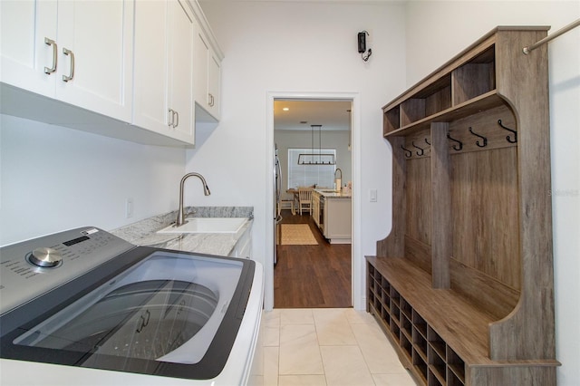 laundry room featuring washer / clothes dryer, light tile patterned floors, cabinets, and sink