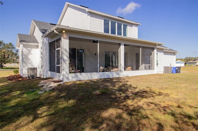 rear view of house with cooling unit, ceiling fan, a yard, and a sunroom