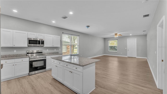 kitchen featuring white cabinetry, plenty of natural light, stainless steel appliances, and a kitchen island