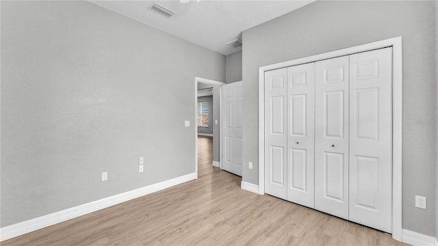 unfurnished bedroom featuring light hardwood / wood-style flooring and a closet