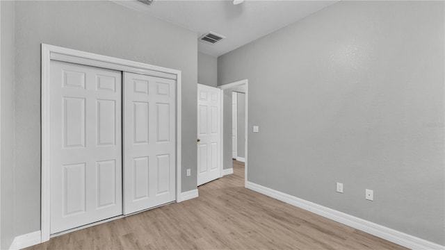 unfurnished bedroom with light hardwood / wood-style floors and a closet