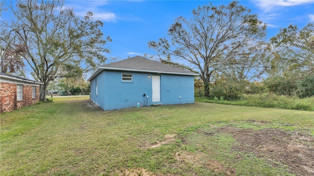 rear view of property featuring a lawn