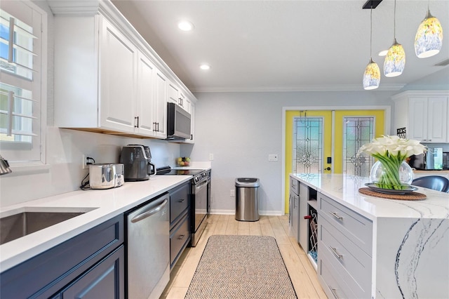 751 Meandering Way, Polk City, FL 33868 - kitchen with stainless steel appliances, light countertops, white cabinetry, and pendant lighting