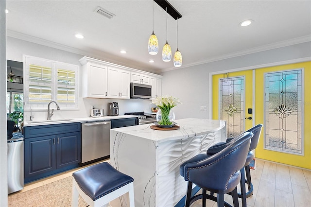 751 Meandering Way, Polk City, FL 33868 - kitchen featuring stainless steel appliances, visible vents, white cabinets, a sink, and a kitchen island