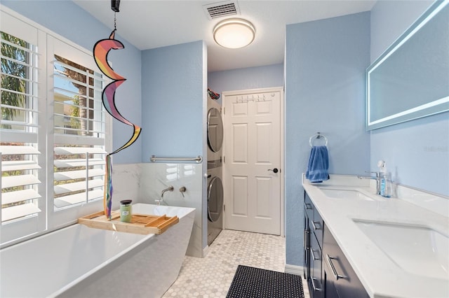 751 Meandering Way, Polk City, FL 33868 - washroom with stacked washer and dryer, laundry area, visible vents, and a sink