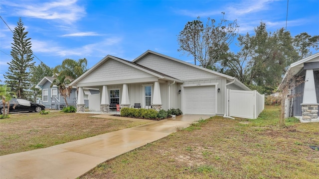 view of front of home featuring an attached garage, board and batten siding, fence, a porch, and driveway