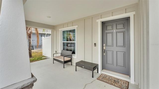 property entrance with covered porch and board and batten siding