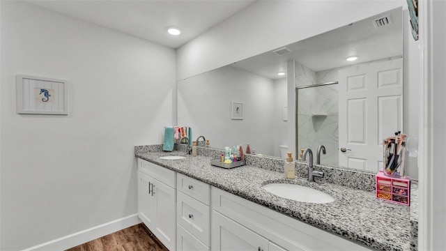 full bath with a sink, visible vents, a marble finish shower, and wood finished floors