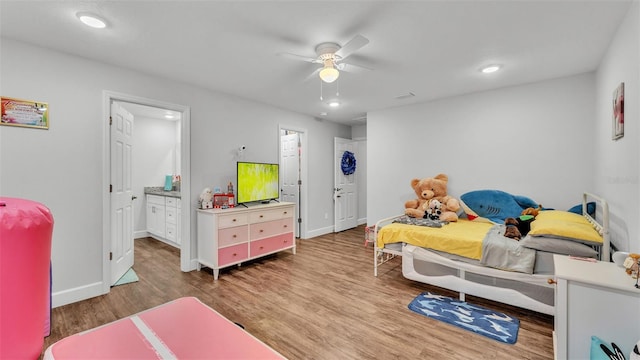 bedroom with recessed lighting, ensuite bath, baseboards, and wood finished floors