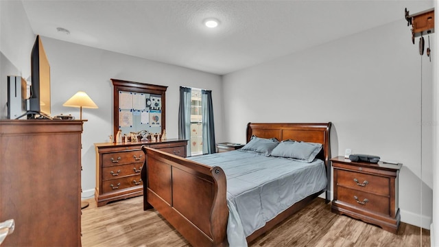 bedroom featuring light wood-type flooring and baseboards