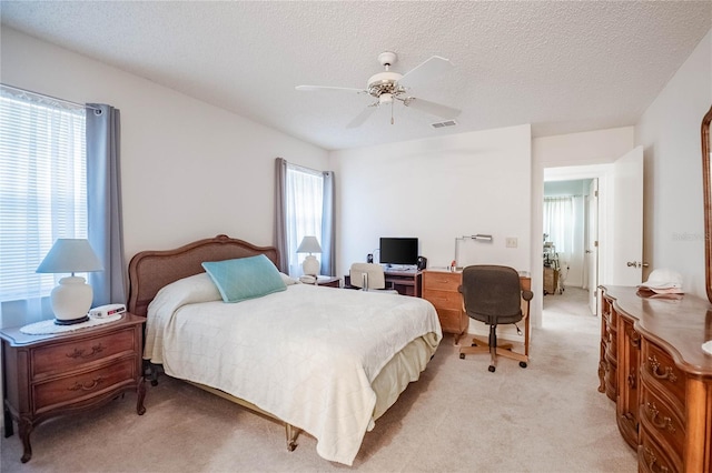 carpeted bedroom with a textured ceiling and ceiling fan