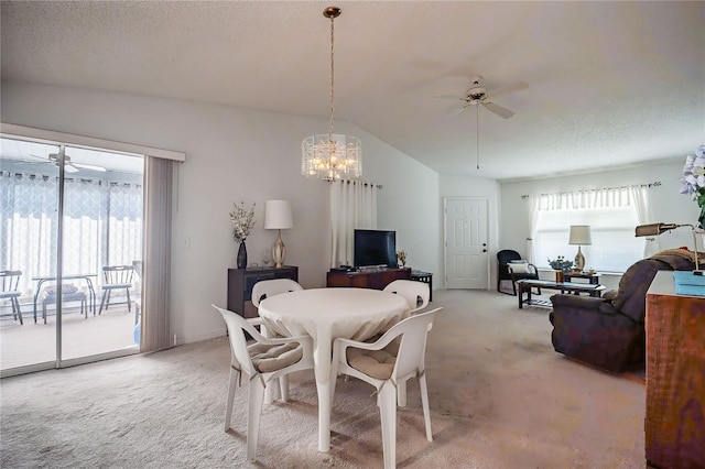 carpeted dining space featuring lofted ceiling, a textured ceiling, and ceiling fan