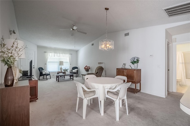 carpeted dining area featuring vaulted ceiling, ceiling fan with notable chandelier, and a textured ceiling