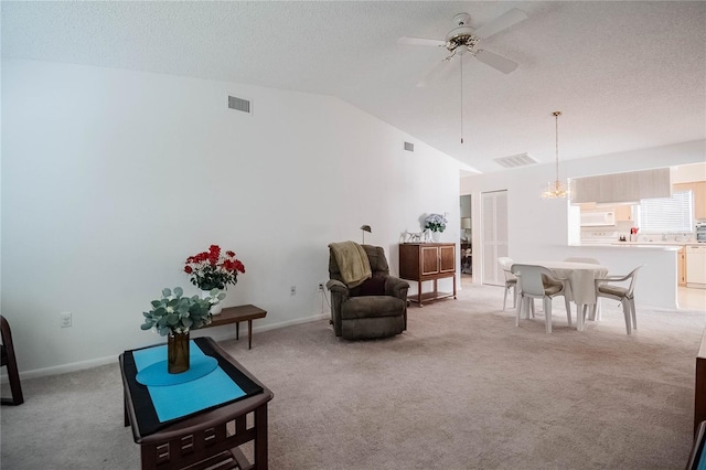 carpeted living room with lofted ceiling, ceiling fan with notable chandelier, and a textured ceiling