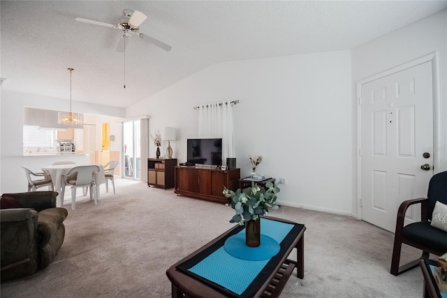 carpeted living room featuring ceiling fan, vaulted ceiling, and a textured ceiling