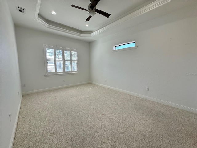 carpeted spare room with crown molding, ceiling fan, and a tray ceiling