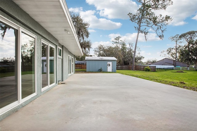 view of patio / terrace with an outbuilding, fence, and a storage shed