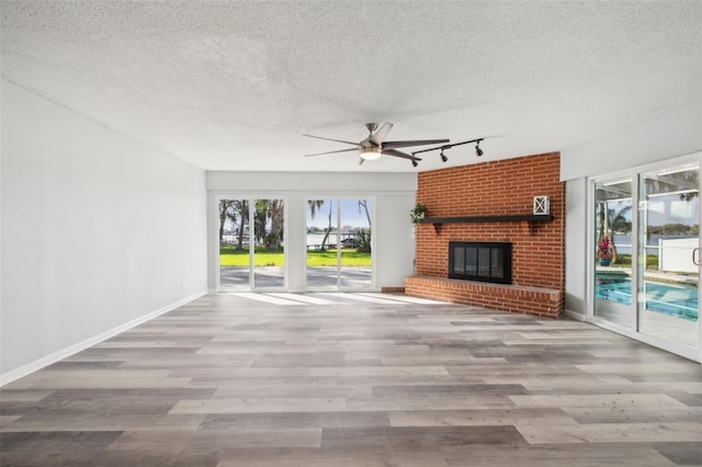 unfurnished living room with a healthy amount of sunlight, a fireplace, and wood finished floors