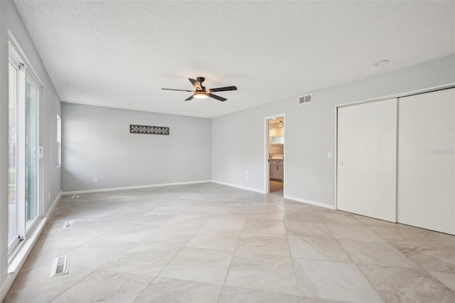 unfurnished bedroom with a ceiling fan, baseboards, visible vents, and a textured ceiling