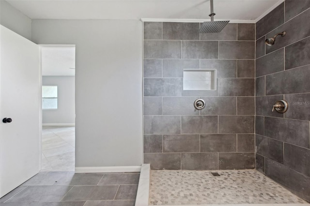 full bath with tile patterned flooring, baseboards, and tiled shower