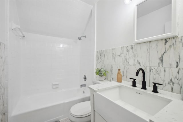 bathroom with tub / shower combination, vanity, toilet, and tile walls