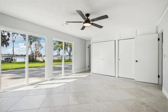 unfurnished bedroom featuring access to exterior, multiple closets, visible vents, a ceiling fan, and a textured ceiling