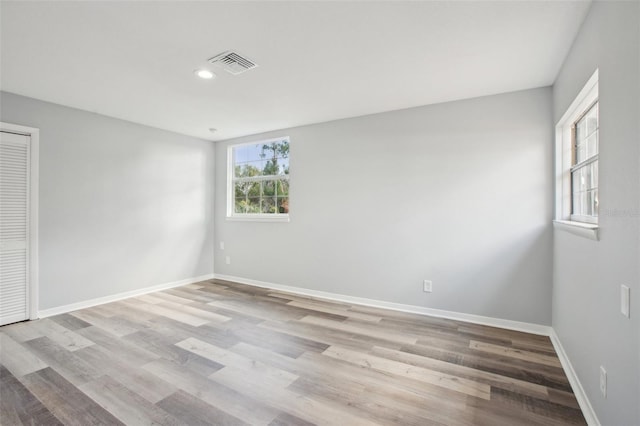 spare room with recessed lighting, visible vents, baseboards, and wood finished floors